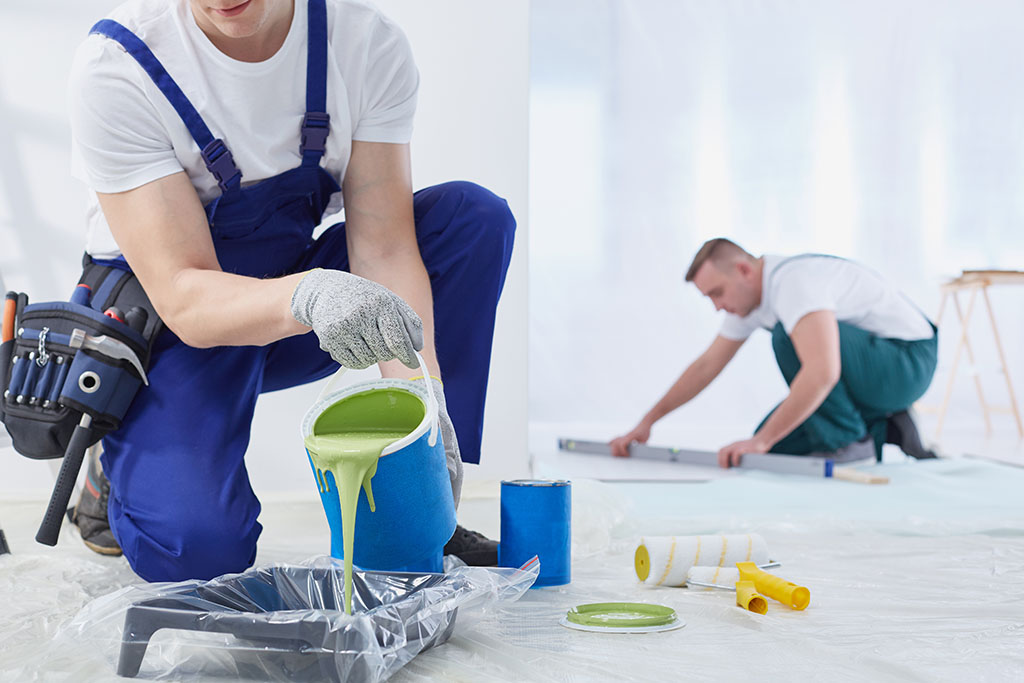 Man painting the walls and spilling the paint